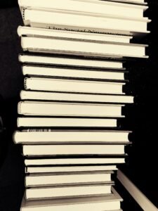 Monochrome image of a stack of books in a library for educational study.
